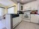 Bright kitchen featuring white cabinetry, modern appliances, and blue countertops with dining space at 13468 Romford Ave, Port Charlotte, FL 33981