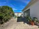 Relaxing backyard patio with sliding glass doors, a comfortable chair, and a variety of potted plants at 13468 Romford Ave, Port Charlotte, FL 33981