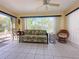 Relaxing sunroom with tile flooring, comfortable seating, and sliding glass doors to the outdoor patio at 13468 Romford Ave, Port Charlotte, FL 33981