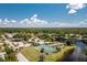 Aerial view showing community pool, tennis courts, and lake at 523 Foxwood Blvd, Englewood, FL 34223