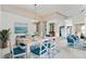 Bright dining room featuring a white table with blue chairs and a lovely seascape painting at 523 Foxwood Blvd, Englewood, FL 34223