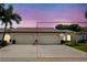 Exterior view of a charming villa with a two-car garage and well-manicured landscaping at 523 Foxwood Blvd, Englewood, FL 34223