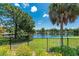 Scenic lake view with lush landscaping and a black fence at 523 Foxwood Blvd, Englewood, FL 34223