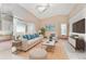 Spacious living room with beige sofa, a coffee table, and a large flat-screen TV at 523 Foxwood Blvd, Englewood, FL 34223