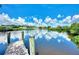 Private dock on a tranquil canal with lush greenery and a sunny sky at 1391 Flamingo Dr, Englewood, FL 34224