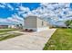 Side view of tan mobile home, landscaping, and boat at 1391 Flamingo Dr, Englewood, FL 34224