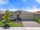 Tan house with dark brown door and paver driveway at 20450 Revival Ln, Venice, FL 34293