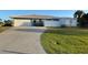 Rear view of house showcasing garage, fenced yard, and shed at 1019 Schooner Ln, Englewood, FL 34224