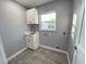 Laundry room with white cabinets and utility sink at 1019 Schooner Ln, Englewood, FL 34224
