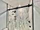 Modern shower with black accents, marble tile, and sliding glass door at 1019 Schooner Ln, Englewood, FL 34224