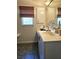 Bathroom vanity with white cabinets, granite counters, and a bronze faucet at 15001 Appleton Blvd, Port Charlotte, FL 33981