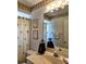 Well-lit bathroom featuring a tropical themed shower curtain, wall art, and vanity at 15001 Appleton Blvd, Port Charlotte, FL 33981
