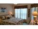 Cozy bedroom with tropical bedding, sheer curtains, and accent lamps at 15001 Appleton Blvd, Port Charlotte, FL 33981