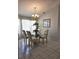 Well-lit dining room featuring a modern chandelier, glass table and floor to ceiling window coverings at 15001 Appleton Blvd, Port Charlotte, FL 33981