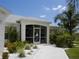 Charming home exterior with lush landscaping and a screened-in porch featuring a decorative sailboat door at 15001 Appleton Blvd, Port Charlotte, FL 33981