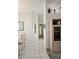Bright hallway featuring tile flooring, neutral walls, and decorative shelving, creating an inviting and airy atmosphere at 15001 Appleton Blvd, Port Charlotte, FL 33981