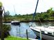 Waterfront property with a canal view highlighting two sailboats docked along the lush green landscape at 15001 Appleton Blvd, Port Charlotte, FL 33981