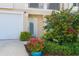 Front entrance of a townhome with well-maintained landscaping and a white garage door at 10309 Coral Landings Ct # 101, Placida, FL 33946