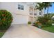 Exterior view of a two-story townhome with a garage and lush landscaping at 10309 Coral Landings Ct # 101, Placida, FL 33946
