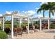 Community pool area with pergola and lounge chairs at 10309 Coral Landings Ct # 101, Placida, FL 33946