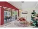 Bright dining area with a table, red accents, and a large sliding door to the screened outdoor space at 163 Jennifer Dr, Rotonda West, FL 33947