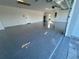View of the garage featuring a finished epoxy floor, utility door, and water heater at 15267 Appleton Blvd, Port Charlotte, FL 33981