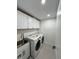 Bright laundry room with washer, dryer, and utility sink at 15267 Appleton Blvd, Port Charlotte, FL 33981