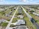 Wide aerial view of a residential area featuring a canal and numerous houses at 261 Broadmoor Ln, Rotonda West, FL 33947