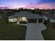 Elevated view of a single-Gathering home at dusk with a three-car garage at 261 Broadmoor Ln, Rotonda West, FL 33947