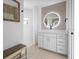 Modern bathroom with a large round mirror and white cabinets at 261 Broadmoor Ln, Rotonda West, FL 33947