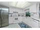 White kitchen with stainless steel appliances and tile floor at 7293 Spinnaker Blvd, Englewood, FL 34224