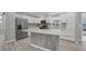 Bright kitchen features an island, white cabinets, stainless steel appliances, and modern backsplash at 740 Summersea Ct, Englewood, FL 34223