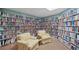 Cozy library room featuring floor-to-ceiling bookshelves and comfortable armchairs with palm tree pattern at 740 Summersea Ct, Englewood, FL 34223