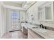 Double vanity bathroom with marble countertop and door to backyard at 101 Pebble Rock Dr, Venice, FL 34293