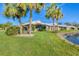 Exterior view of the house with palm trees and pond view at 101 Pebble Rock Dr, Venice, FL 34293