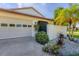 White house with attached garage, landscaping, and a palm tree at 101 Pebble Rock Dr, Venice, FL 34293