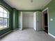 Green-walled bedroom with tile floors and a double-door closet at 35 Mark Twain Ln, Rotonda West, FL 33947