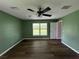 Bedroom with ceiling fan, large window, and hardwood floors at 35 Mark Twain Ln, Rotonda West, FL 33947