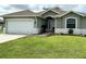 House exterior view with green siding and a white garage door at 35 Mark Twain Ln, Rotonda West, FL 33947