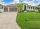 Modern home with three-car garage and lush landscaping at 15320 Hennipen Cir, Port Charlotte, FL 33981