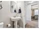 Clean and contemporary half bathroom with pedestal sink and a linen closet at 7537 Pool Compass Loop, Wesley Chapel, FL 33545