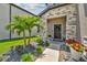 Landscaped front yard with palm trees and stone pathway at 7537 Pool Compass Loop, Wesley Chapel, FL 33545