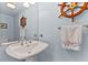Cozy powder room with an unusual pedestal sink and nautical themed decor at 11000 Placida Rd # 2303, Placida, FL 33946