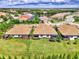 Beautiful aerial view of the home, showcasing the lush lawn, landscaping, and serene pond views at 26950 Pavin Dr, Englewood, FL 34223