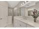 Bright bathroom featuring a large vanity with double sinks and a glass-enclosed shower at 26950 Pavin Dr, Englewood, FL 34223