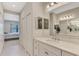 Well-lit bathroom with dual sinks, large mirror, and an open view to the bedroom at 26950 Pavin Dr, Englewood, FL 34223