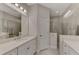 Bathroom featuring a glass shower, large mirror, and vanity with stone countertop at 26950 Pavin Dr, Englewood, FL 34223