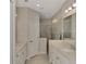 Bright bathroom featuring double sinks, granite countertops, and tiled shower with glass door at 26950 Pavin Dr, Englewood, FL 34223