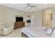 Well-lit bedroom featuring a ceiling fan, television, and a view into the living area at 26950 Pavin Dr, Englewood, FL 34223