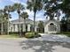 Stately community clubhouse featuring a porte-cochere and lush landscaping at 26950 Pavin Dr, Englewood, FL 34223